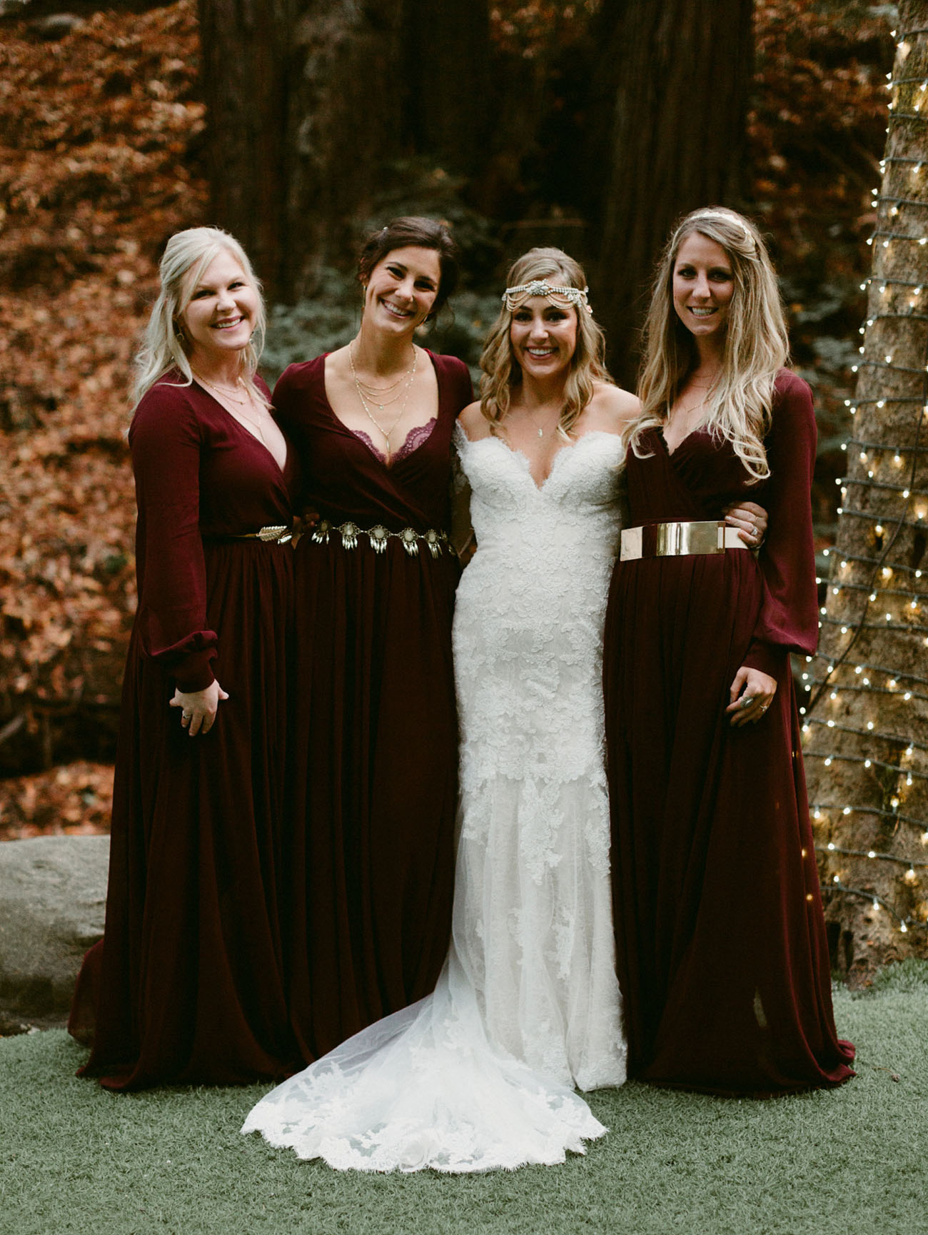 The bride was wearing a strapless lace dress with a train, and the bridesmaids rocked burgundy dresses with different belts