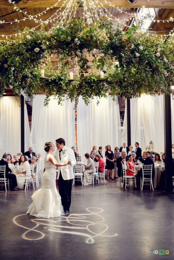 oversized leafe chandelier with some white roses over the dance floor