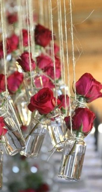 hanging jars with red roses over the reception