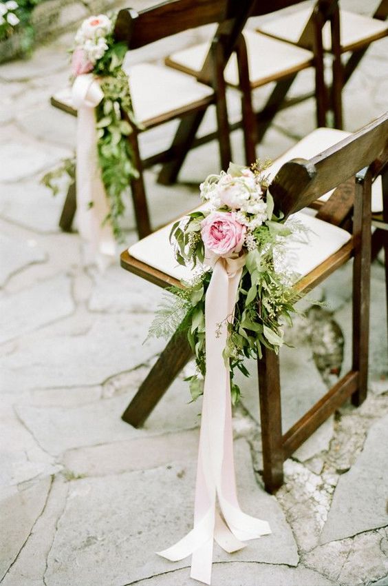 aisle chairs with fresh flowers, greenery and ivory ribbon