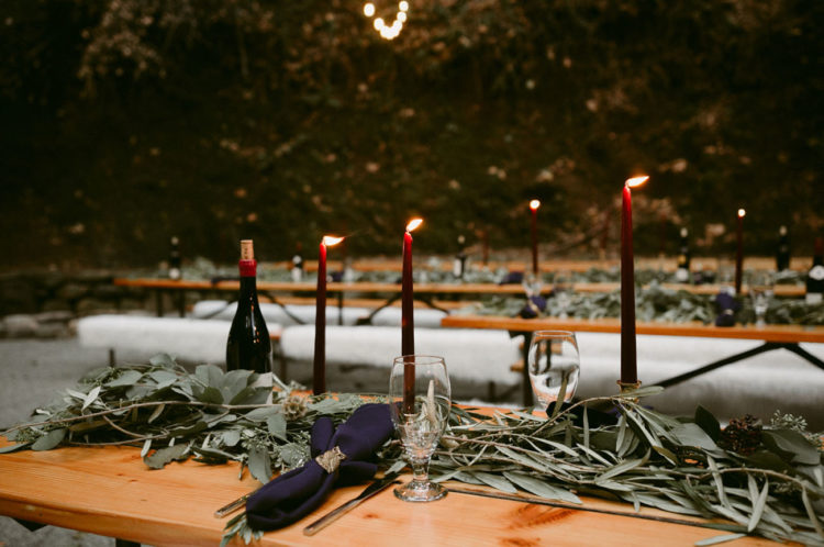 Fresh greenery runners, navy napkins and burgundy candles looked magical
