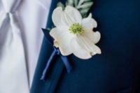 15 navy suit, a white shirt and tie, a white flower boutonniere