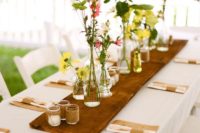 15 spring table setting with a wooden board, candles and flowers on it