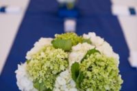 16 greenery and white hydrangeas on a bold blue table runner