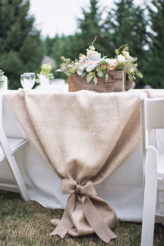 burlap table runner and a crate with flowers for a rustic table setting