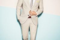 22 cream-colored suit with a polka dot tie and light brown suede boots