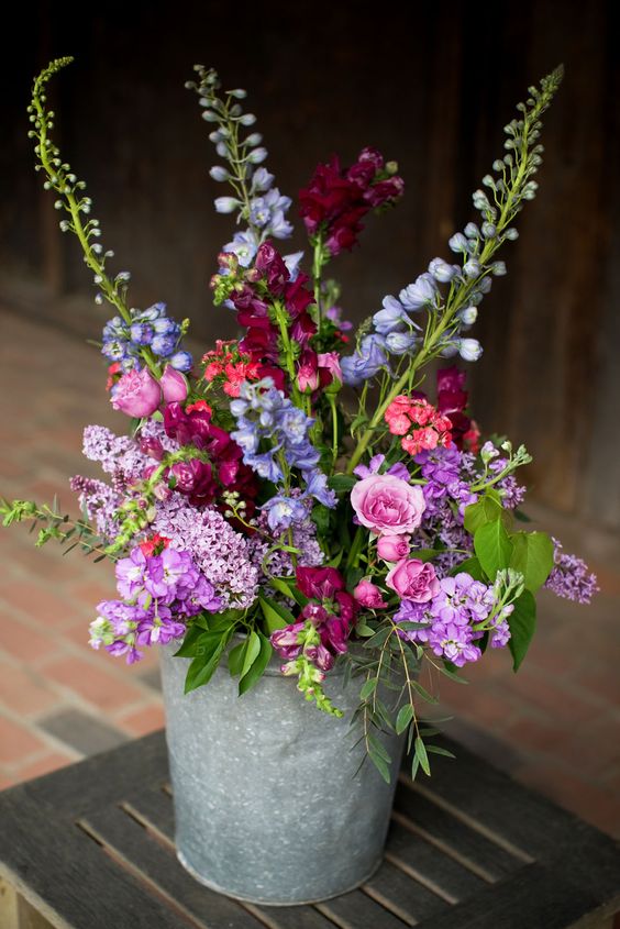 purple, pink and blue wildflowers in a bucket