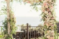 31 rustic wedidng arch with lush florals in ivory and pink shadeds