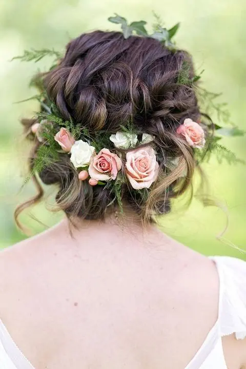 wavy and twisted updo with fresh flowers and greenery