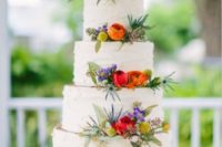 33 beautiful white wedding cake with floral decor displayed on a wooden slice