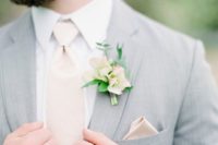 33 light grey suit, a blush tie and boutonniere