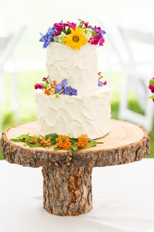 frosted wildflower cake topped with violet, yellow and fuchsia flowers