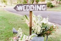 34 wedding sign with watering cans instead of vases