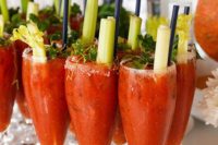 35 fresh bloody marys are topped with celery sticks and herbs