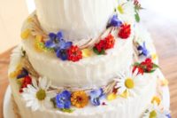 37 bright wildflowers on a frosted wedding cake