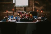 06 Black candles, blue glasses and a lush moody floral and leaf centerpiece rocked this table setting