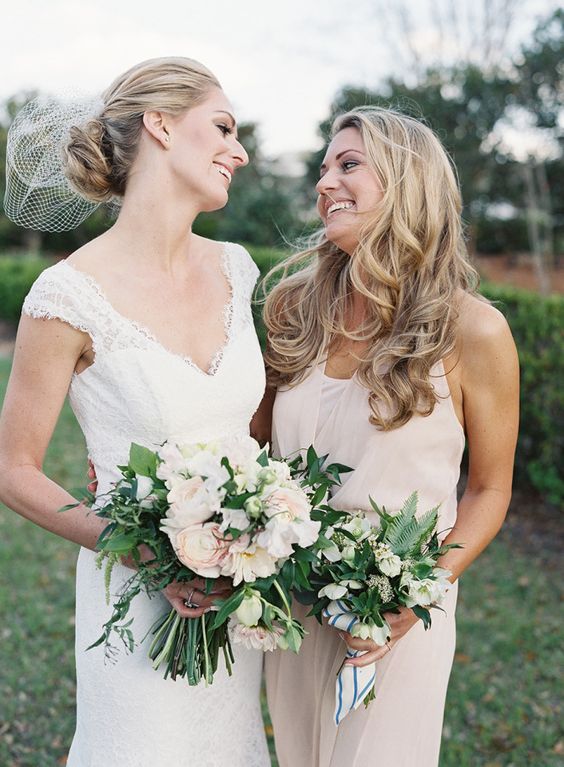 the bride in an ivory V-neck dress and her maid of honor in off-white