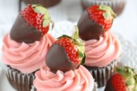 12 chocolate cupcakes with pink glazing and strawberries