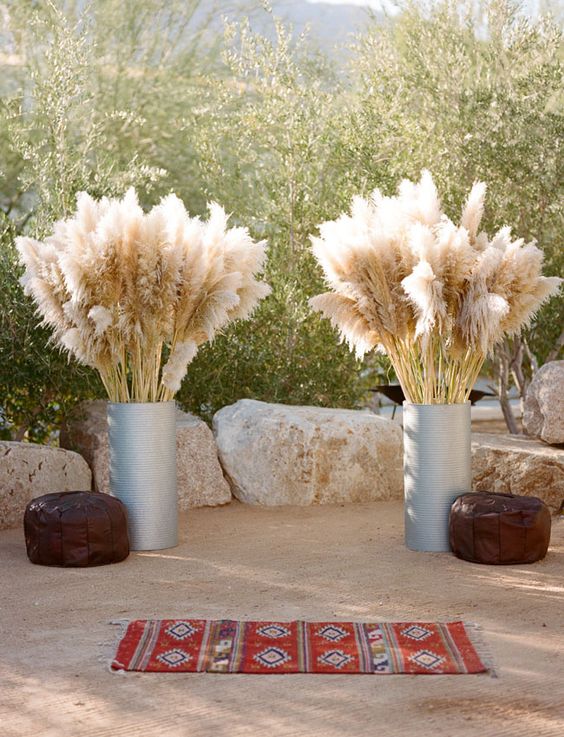 wedding altar with a boho rug, leather ottomans and pampas in galvanized urns