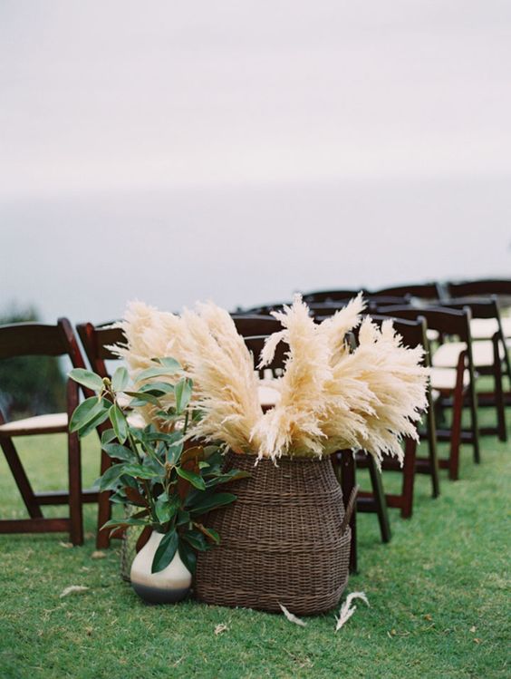 a basket with pampas grass for wedding aisle decor