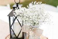 17 stylish centerpiece with a candle lantern and a mason jar with baby’s breath