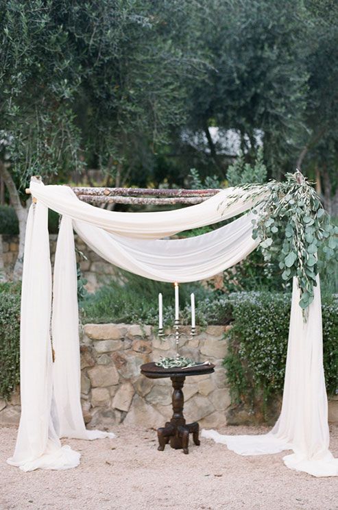 wedding arch with light fabrics and eucalyptus