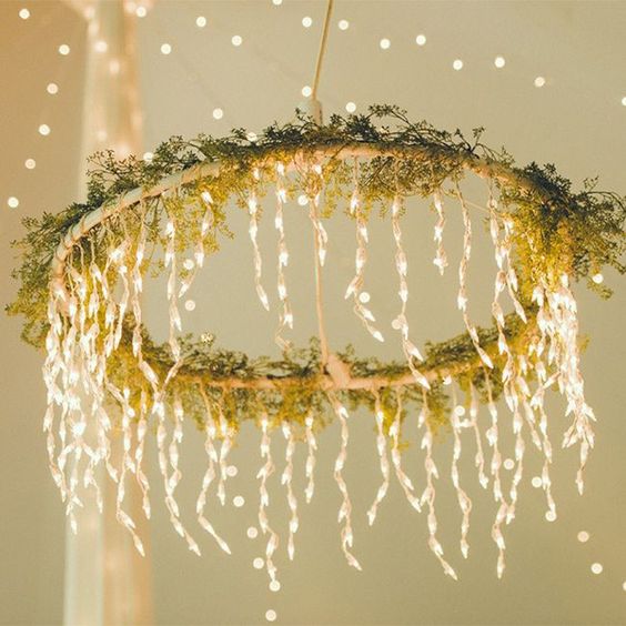 gorgeous chandelier made by wrapping a hoop in twinkling lights and fresh greenery