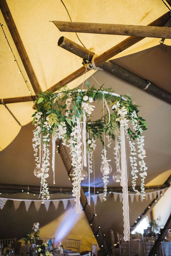 greenery and white flowers on a hoop as a wedding chandelier