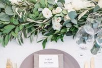 24 cream-colored wedding tablescape with a greenery and flower runner and a grey place setting