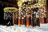 24 hoops covered with lush greenery adn florals as wedding chandeliers