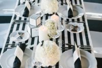 24 modern black tie wedding decor with a striped tablecloth and white florals