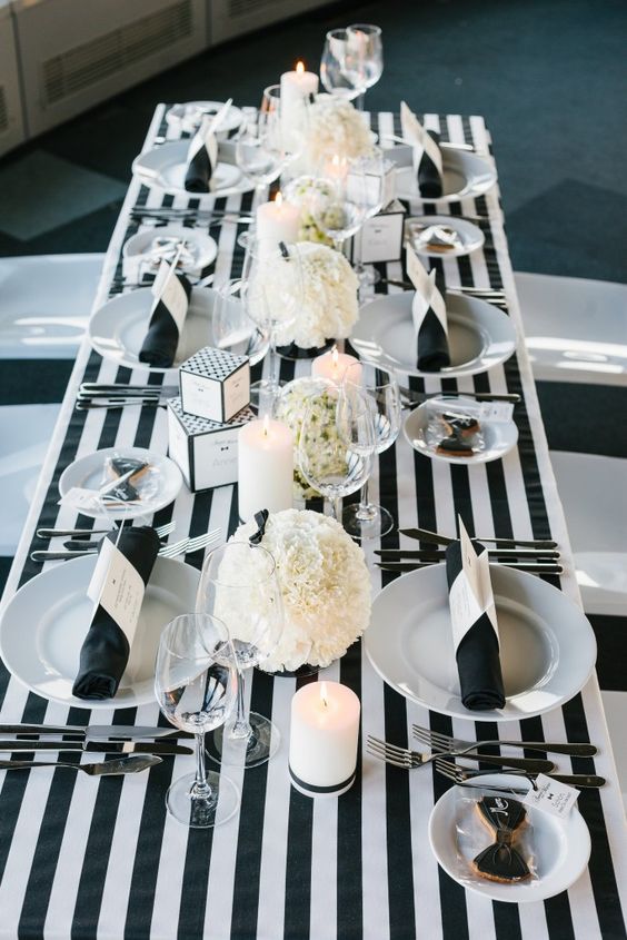 modern black tie wedding decor with a striped tablecloth and white florals