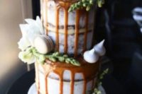 27 salted caramel drip wedding cake topped with macarons and meringues