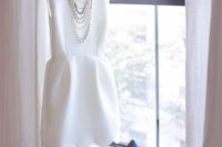29 white plain mini dress with a scalloped hem and bold blue heels