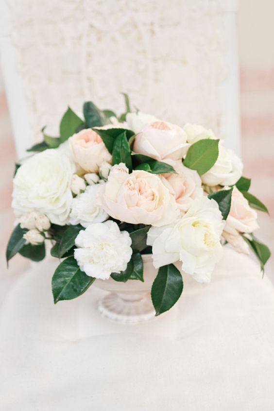 cream and blush flower centerpiece with green leaves