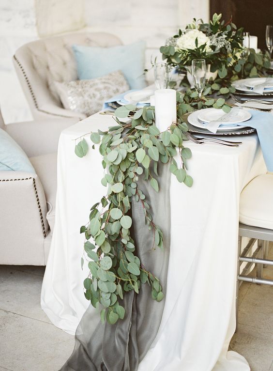 fabric table runner and a eucalyptus garland over it look very delicate