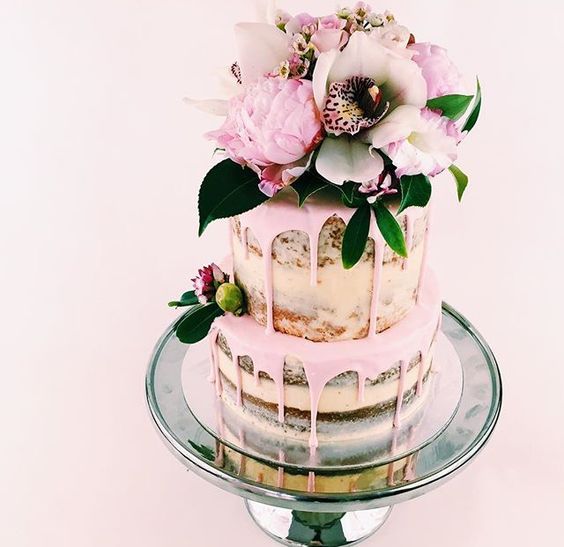 semi naked pink drip wedding cake with flowers and greenery