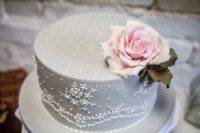 34 dove grey one-tier lace wedding cake topped with a flower