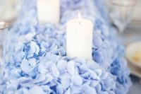 37 pale blue hydrangeas create a lush bed for placing a row of candles