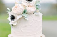 38 frosted neutral cake with blush flowers on top