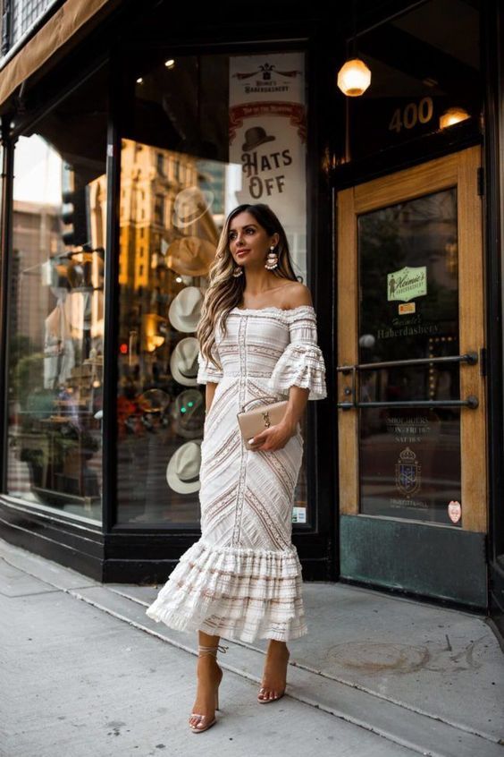 a boho lace fitting off the shoulder midi dress, lace up shoes and a small nude bag plus statement earrings