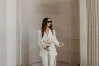 a classy white pantsuit with flare pants and white shoes is great for any wedding-related party or a wedding