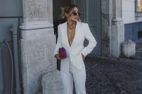 a fun and cool bridal shower look with a white pantsuit, red and white sneakers, layered necklaces and sunglasses