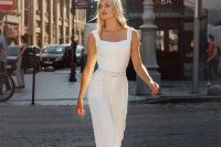 a modern look with a white jumpsuit with straps and wideleg pants plus pockets and thin belts on the waist