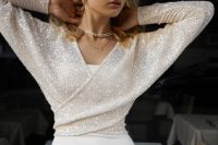 a plain white dress paired with a white sequin wrap crop top with long sleeves is a lovely idea
