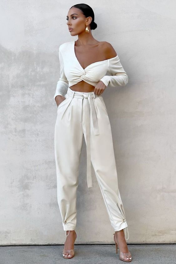 a sexy bridal shower look with a one shoulder crop top, high waisted pants, clear shoes and statement earrings