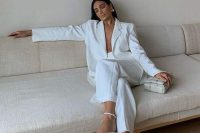 a white pantsuit with wideleg pants, strappy shoes and a woven bag are a super edgy combo for a bridal shower
