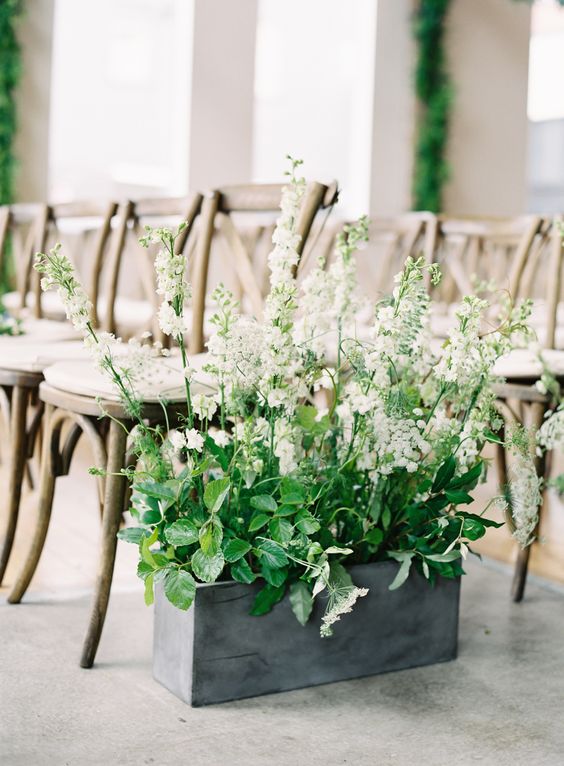 a box with greenery and flowers for aisle decor
