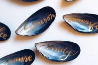 02 blue oyster shells with gold calligraphy as escort cards and favors in one