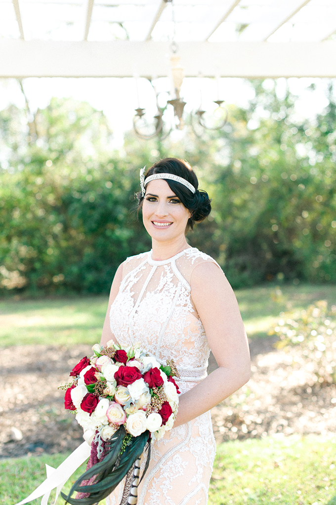 The bride was also rocking an upso with a refined sparkly headpiece and a bold bouquet decorated with feathers